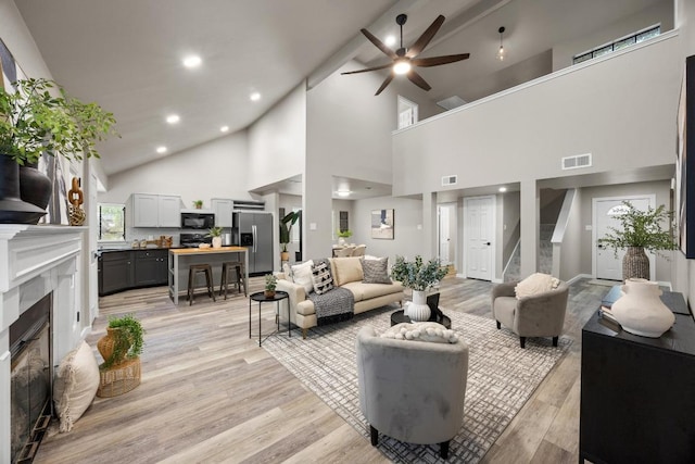 13105 Lubbock Ln, Austin, TX 78729 - living area featuring a fireplace, a ceiling fan, light wood-style flooring, high vaulted ceiling, and recessed lighting