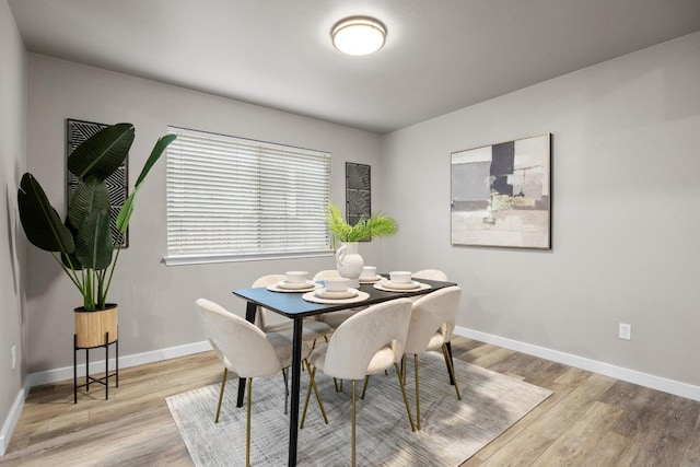 dining room with light wood-type flooring and baseboards