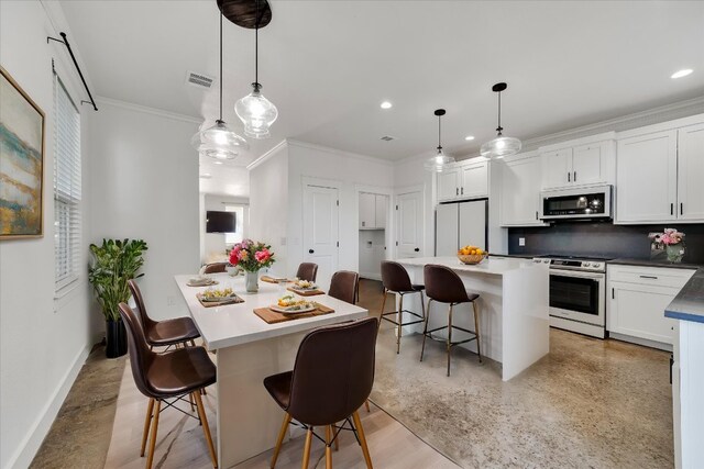 294 Shady Bluff Dr, Wimberley, TX 78676 - kitchen featuring ornamental molding, stainless steel appliances, a kitchen island, and visible vents