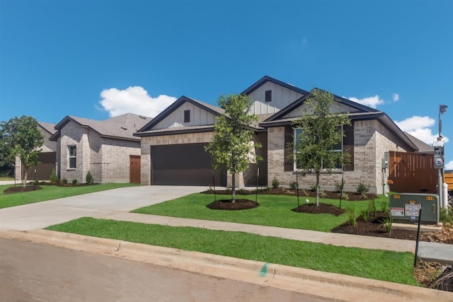 view of front of house with an attached garage, concrete driveway, board and batten siding, a front lawn, and brick siding