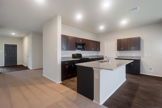 kitchen featuring dark brown cabinets, a sink, visible vents, baseboards, and black appliances