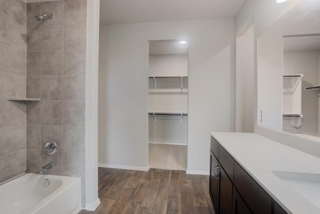 2428 Ambling Trl, Georgetown, TX 78628 - bathroom with wood finished floors, vanity, bathing tub / shower combination, a walk in closet, and baseboards
