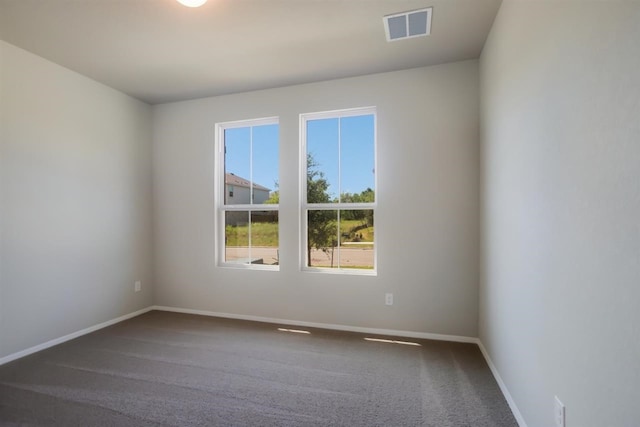 carpeted empty room featuring baseboards and visible vents
