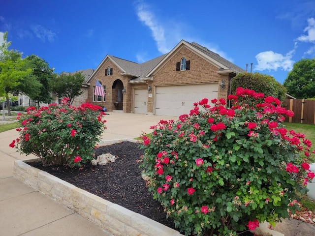 152 Florenz Ln, Georgetown, TX 78628 - view of front of property with an attached garage, brick siding, driveway, and fence