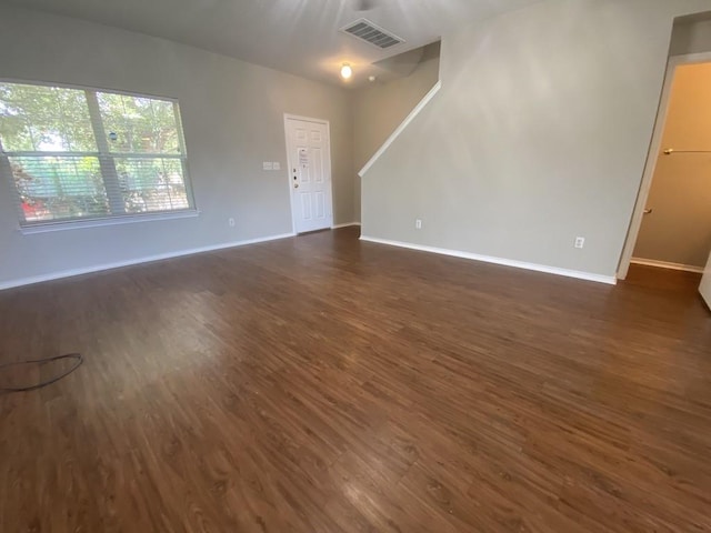 330 Mistletoe Ln, Kyle, TX 78640 - unfurnished living room featuring baseboards, dark wood-type flooring, and visible vents