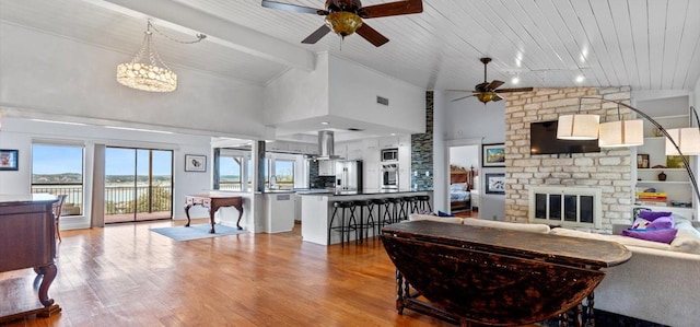6714 Mtn Trl, Austin, TX 78732 - living room with a ceiling fan, wood finished floors, a brick fireplace, high vaulted ceiling, and wooden ceiling with exposed beams