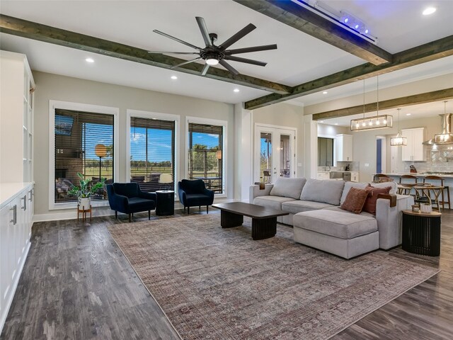 living area featuring a ceiling fan, recessed lighting, baseboards, dark wood-type flooring, and beamed ceiling