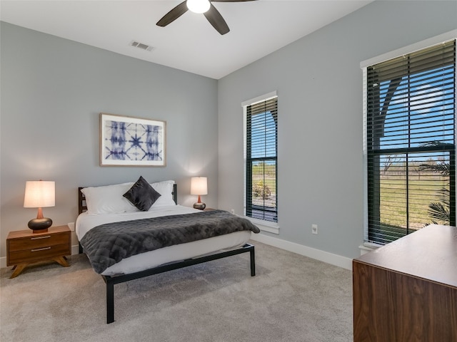 bedroom with light colored carpet, baseboards, a ceiling fan, and visible vents