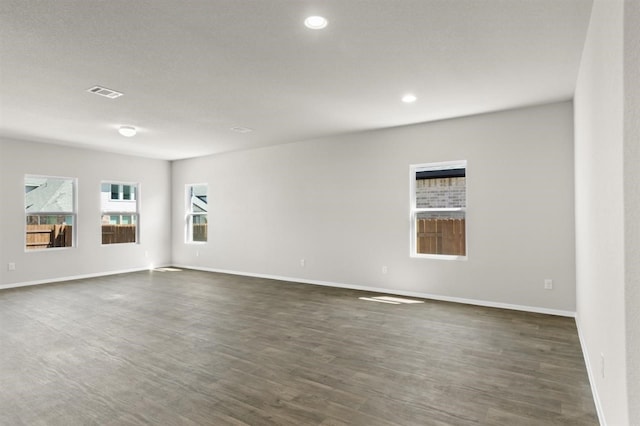 unfurnished room featuring baseboards, dark wood-style flooring, recessed lighting, and visible vents