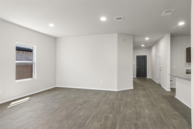 spare room with recessed lighting, baseboards, visible vents, and dark wood finished floors