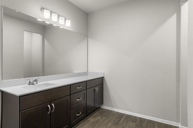 bathroom featuring baseboards, wood finished floors, and vanity