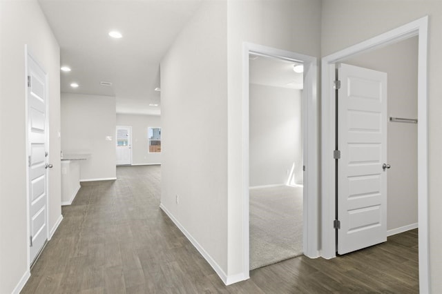 hallway featuring dark wood finished floors, baseboards, and recessed lighting