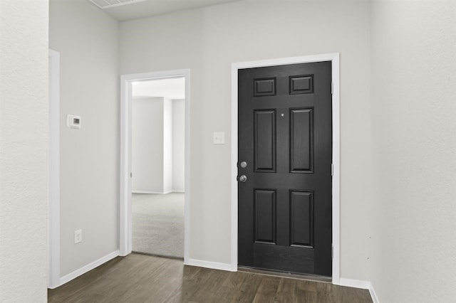 foyer featuring baseboards and dark wood-style floors