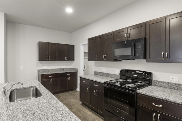 kitchen with black appliances, dark wood finished floors, a sink, and dark brown cabinetry