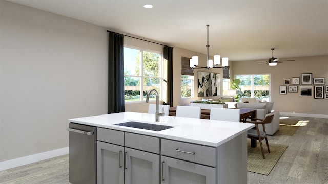 kitchen with light wood-style flooring, a sink, open floor plan, gray cabinets, and baseboards