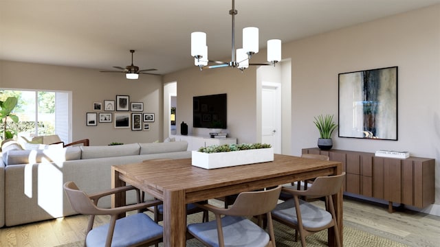 dining area featuring light wood-style flooring and ceiling fan with notable chandelier