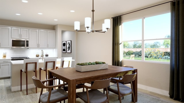 dining space featuring recessed lighting, a notable chandelier, baseboards, and light wood-style floors
