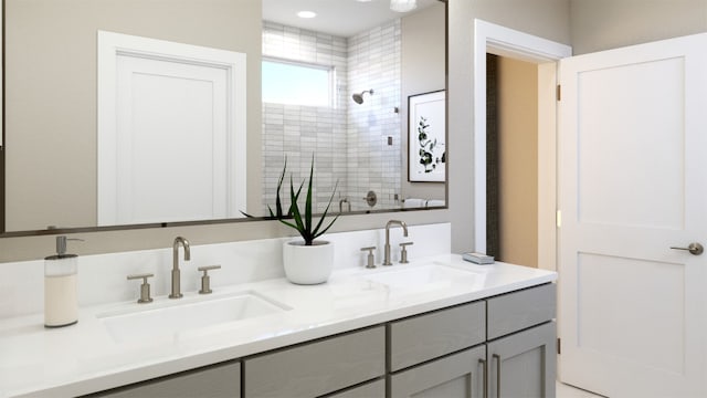 full bath with a tile shower, double vanity, and a sink