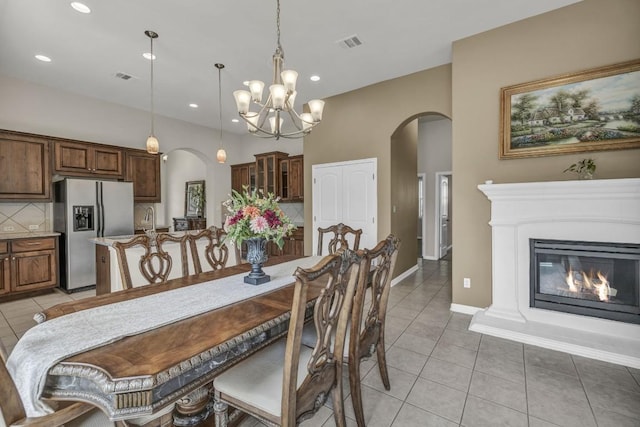 3821 Tordera Dr, Austin, TX 78738 - dining area with an inviting chandelier, light tile patterned floors, visible vents, and arched walkways