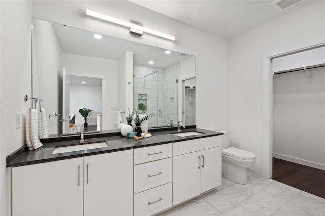 900 S 1st St S Unit 404, Austin, TX 78704 - bathroom with a stall shower, double vanity, marble look tile flooring, toilet, and a spacious closet