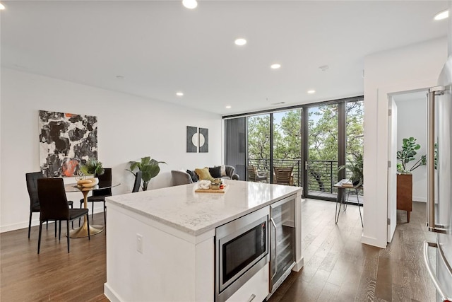 900 S 1st St S Unit 404, Austin, TX 78704 - kitchen with stainless steel microwave, beverage cooler, dark wood-style flooring, a kitchen island, and recessed lighting