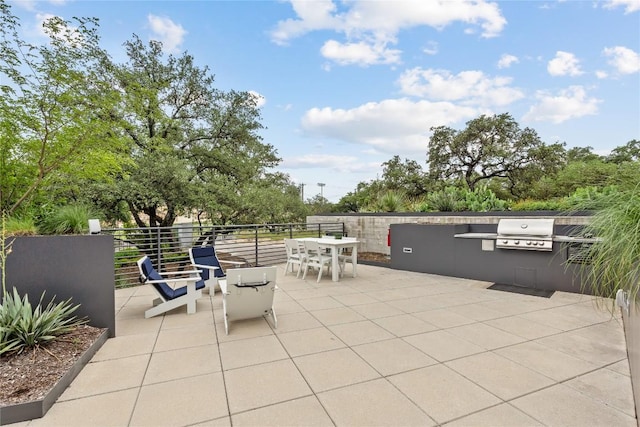 view of patio featuring outdoor dining space, an outdoor kitchen, and grilling area