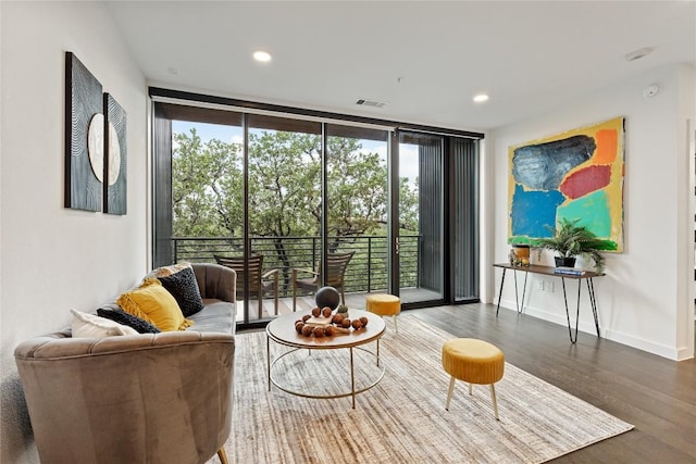 living room featuring floor to ceiling windows, wood finished floors, plenty of natural light, baseboards, and recessed lighting