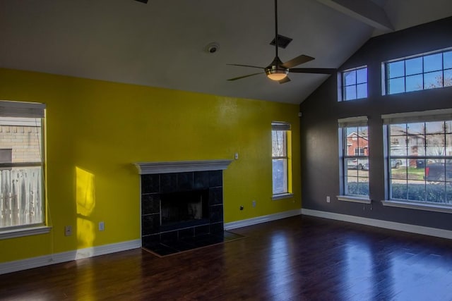 unfurnished living room featuring a tile fireplace, wood finished floors, a ceiling fan, high vaulted ceiling, and baseboards
