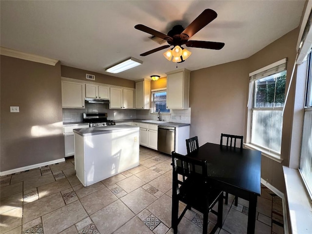 kitchen featuring stainless steel appliances, under cabinet range hood, decorative backsplash, a center island, and baseboards