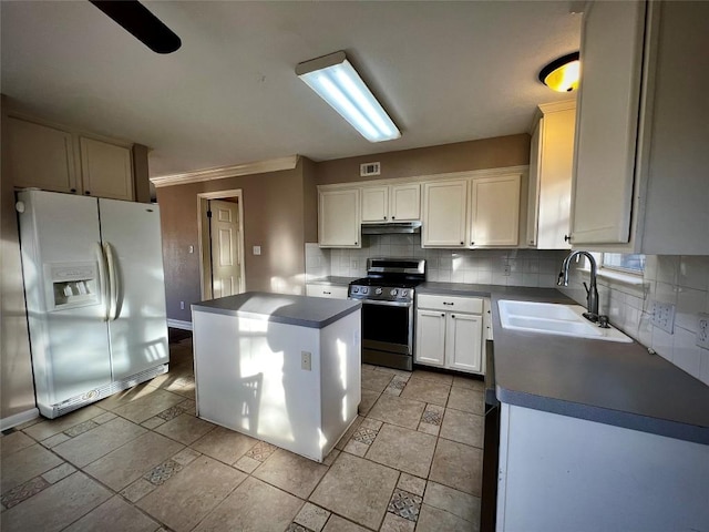 kitchen featuring a sink, tasteful backsplash, white fridge with ice dispenser, stainless steel electric range oven, and dark countertops