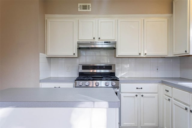 kitchen featuring stainless steel gas range oven, white cabinetry, visible vents, under cabinet range hood, and light countertops