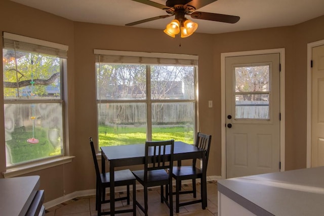 dining area featuring ceiling fan, light tile patterned floors, and a healthy amount of sunlight
