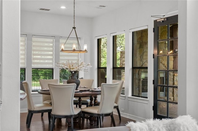 dining area with a chandelier, plenty of natural light, visible vents, and wood finished floors