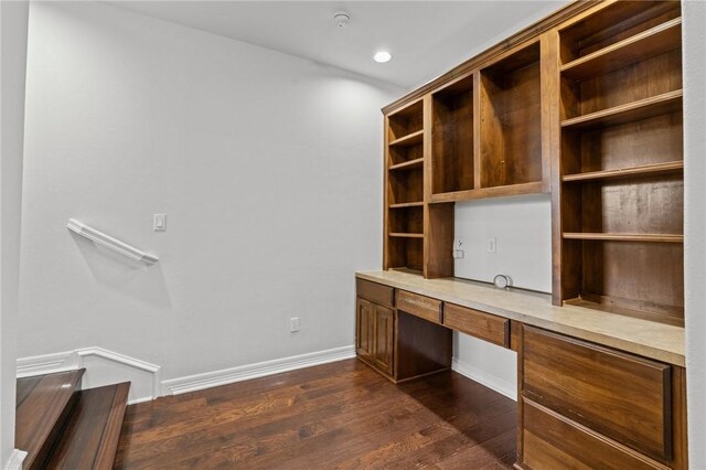unfurnished office with baseboards, dark wood-style floors, recessed lighting, and built in study area