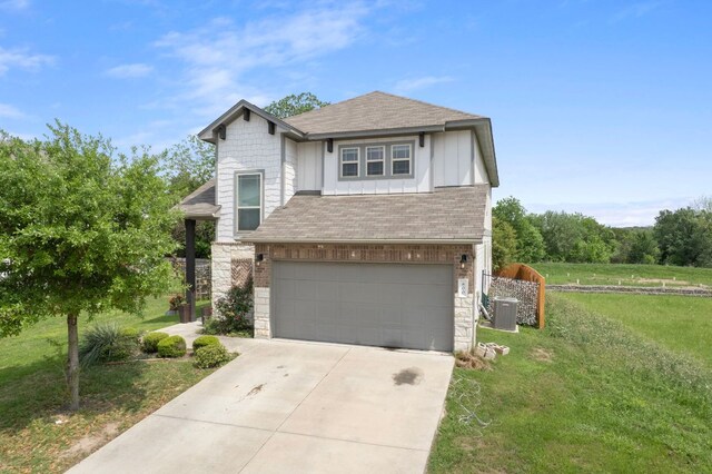 800 Totis Rd, Austin, TX 78748 - view of front of home with stone siding, a garage, roof with shingles, driveway, and a front yard