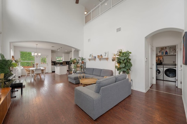 800 Totis Rd, Austin, TX 78748 - living room featuring a notable chandelier, washing machine and dryer, a high ceiling, visible vents, and dark wood-style floors