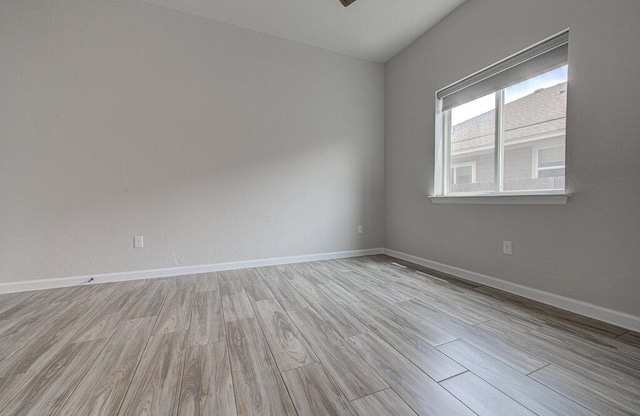 unfurnished room with baseboards and light wood finished floors
