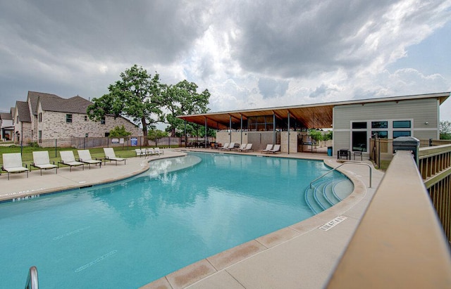 community pool with fence and a patio