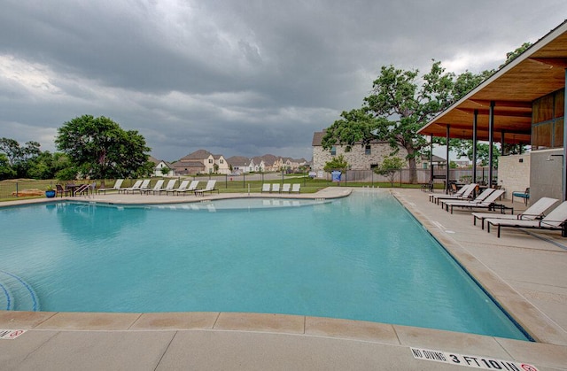 community pool with fence and a patio