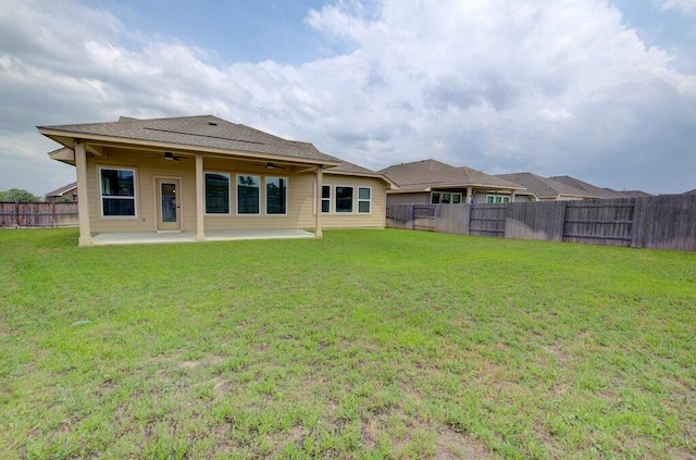 back of house featuring a fenced backyard, a patio, a ceiling fan, and a lawn