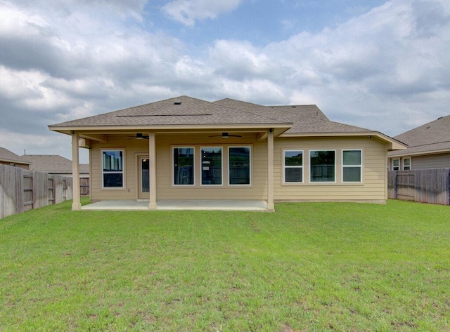 back of house featuring a lawn, a patio, ceiling fan, a shingled roof, and a fenced backyard