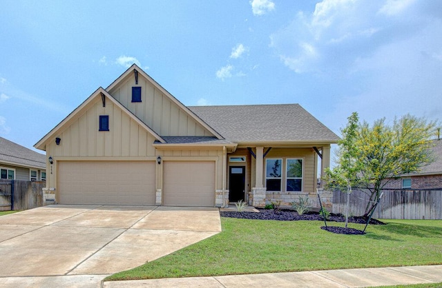 craftsman inspired home featuring a front yard, fence, driveway, and board and batten siding