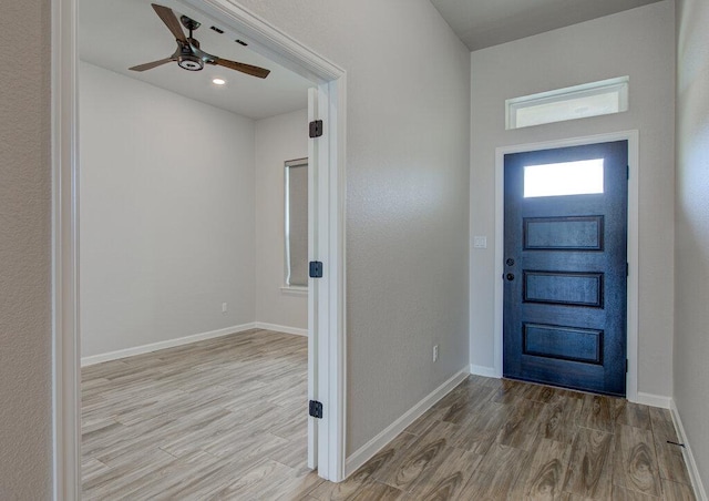 entryway featuring a ceiling fan, baseboards, and wood finished floors