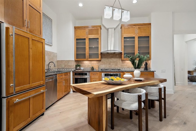 3007 Windsor Rd Unit B, Austin, TX 78703 - kitchen with appliances with stainless steel finishes, a sink, wall chimney exhaust hood, light wood-style floors, and backsplash