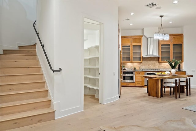 3007 Windsor Rd Unit B, Austin, TX 78703 - kitchen featuring wall chimney exhaust hood, oven, light wood-style floors, decorative backsplash, and recessed lighting