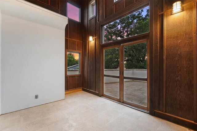 3007 Windsor Rd Unit B, Austin, TX 78703 - doorway to outside with healthy amount of natural light, a high ceiling, and wood walls