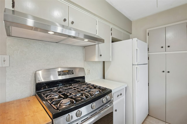 7000 Miranda Dr, Austin, TX 78752 - kitchen with stainless steel range with gas stovetop, exhaust hood, light countertops, and freestanding refrigerator