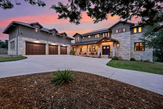 21216 Bertram Ln, Spicewood, TX 78669 - view of front facade with stone siding, solar panels, a standing seam roof, and curved driveway