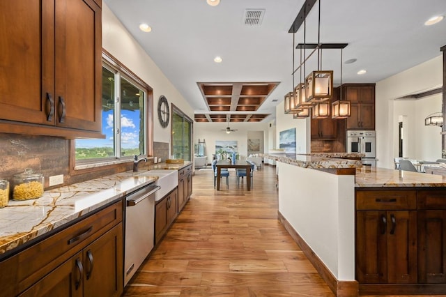 21216 Bertram Ln, Spicewood, TX 78669 - kitchen featuring recessed lighting, light wood-style flooring, a sink, stainless steel appliances, and backsplash