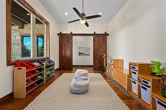 21216 Bertram Ln, Spicewood, TX 78669 - sitting room featuring a ceiling fan, dark wood-style floors, a barn door, and vaulted ceiling